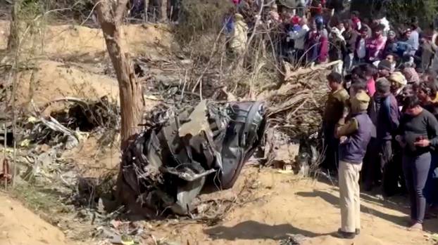 People gather around the debris of a crashed aircraft in Bharatpur