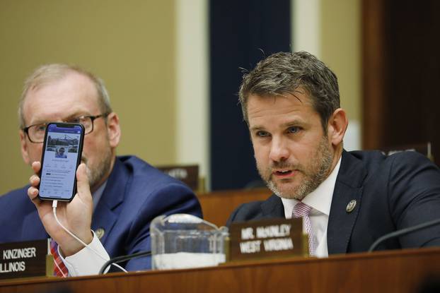 Rep. Kinzinger holds up his phone displaying a fake Facebook profile as Facebook CEO Zuckerberg testifies before the House Energy and Commerce Committee on Capitol Hill in Washington