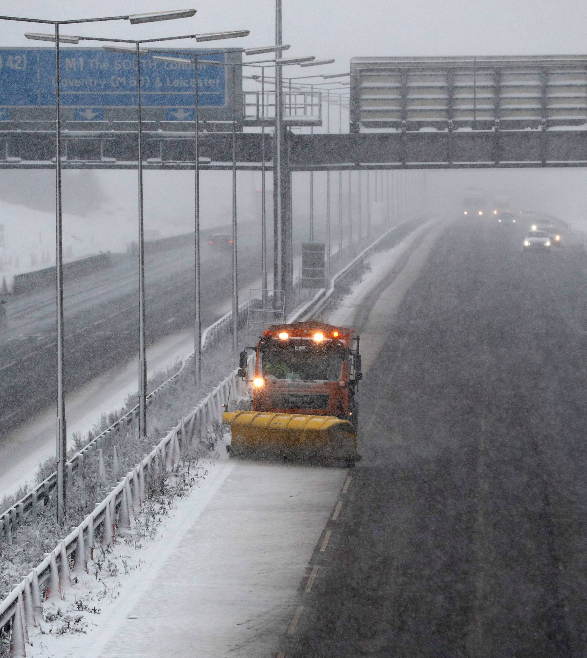 A road gritting vehicle treats the M1 motorway as the snow falls near Kegworth