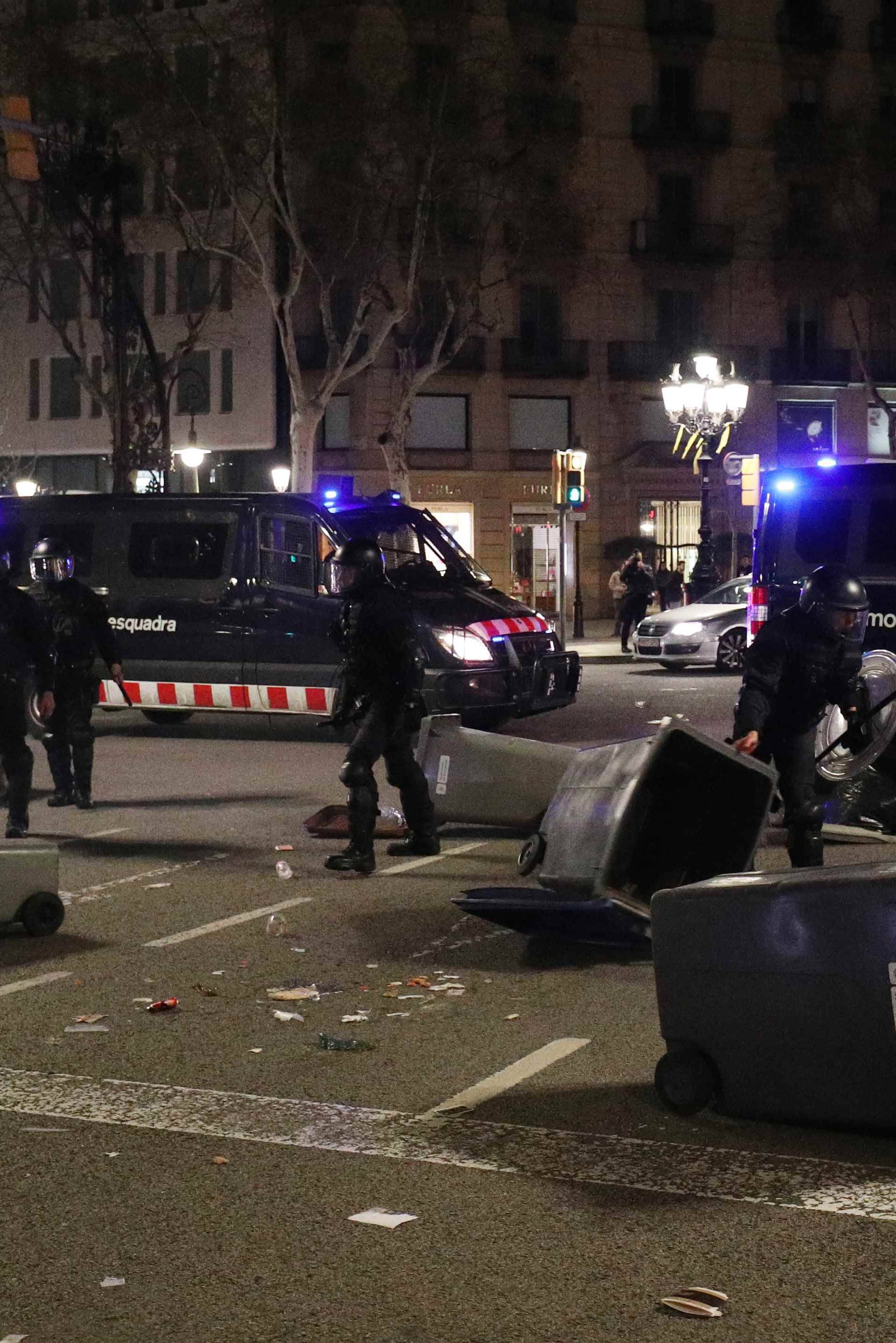 Catalan police remove trash bins used as barricades by protestors during skirmishes after former regional president Carles Puigdemont was detained in Germany,  in Barcelona