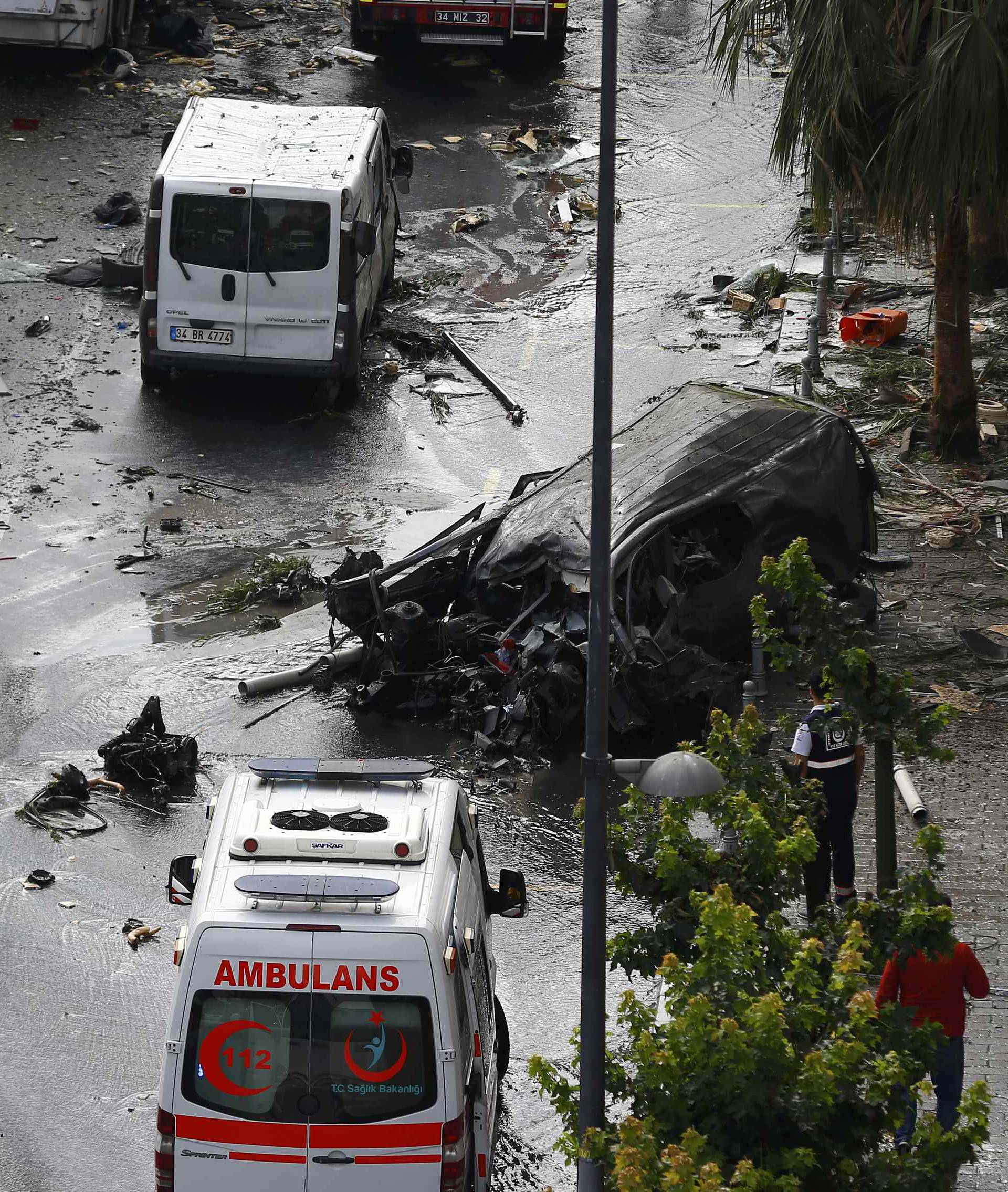 A destroyed van is pictured near a Turkish police bus which was targeted in a bomb attack in a central Istanbul district