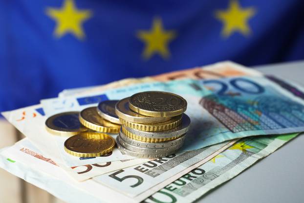 Coins,And,Banknotes,On,Table,Against,European,Union,Flag,,Closeup