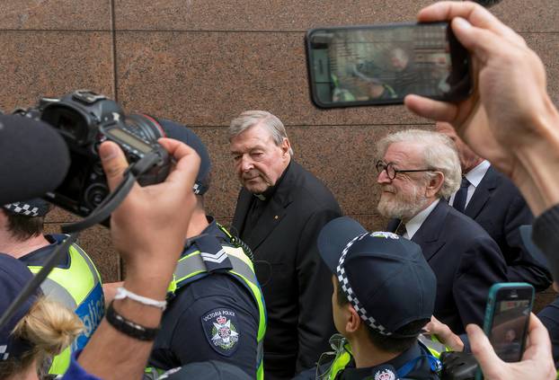 FILE PHOTO - Vatican Treasurer Cardinal George Pell is surrounded by Australian police and members of the media as he leaves the Melbourne Magistrates Court in Australia