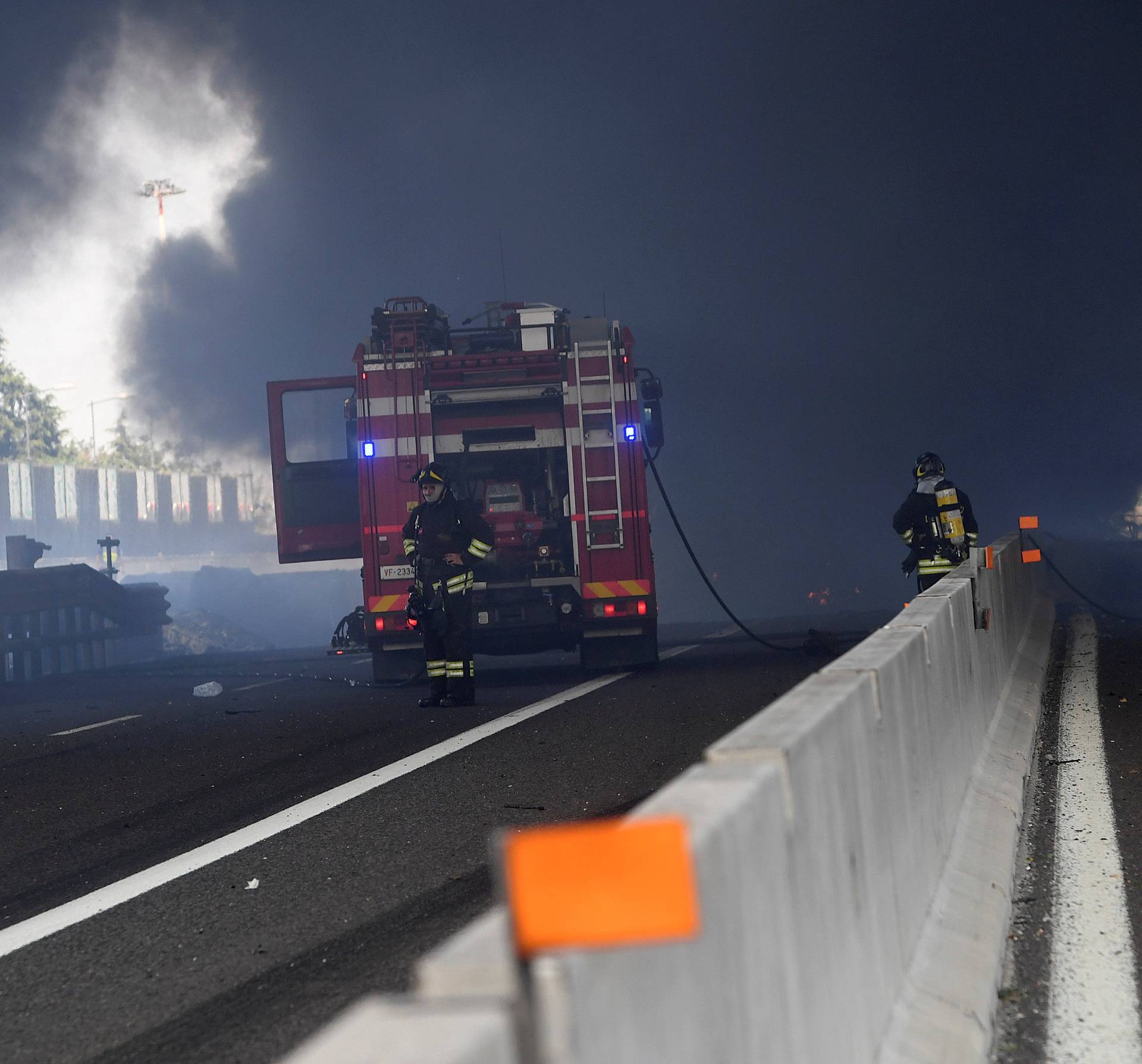 Firefighters work on the motorway after an accident caused a large explosion and  fire at Borgo Panigale, on the outskirts of Bologna