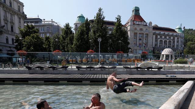 Men cool off in a fountain in Budapest