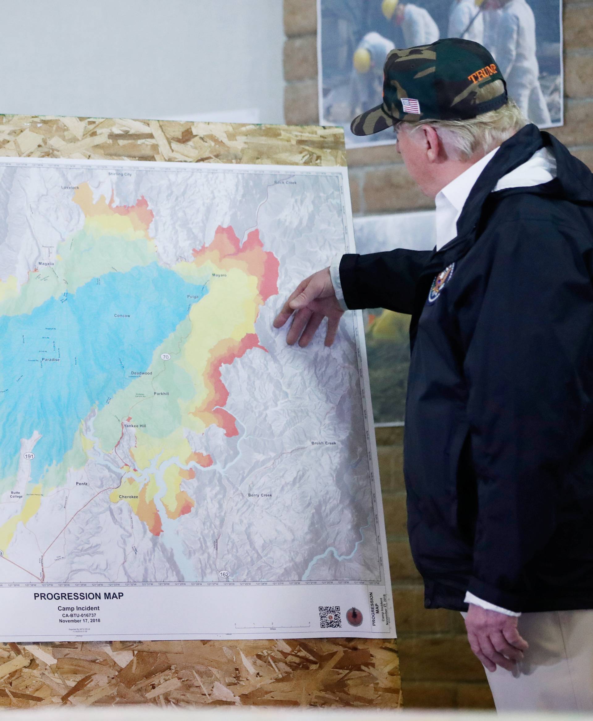 President Donald Trump views the map with Josh Bischof after visiting the charred wreckage of in Paradise California