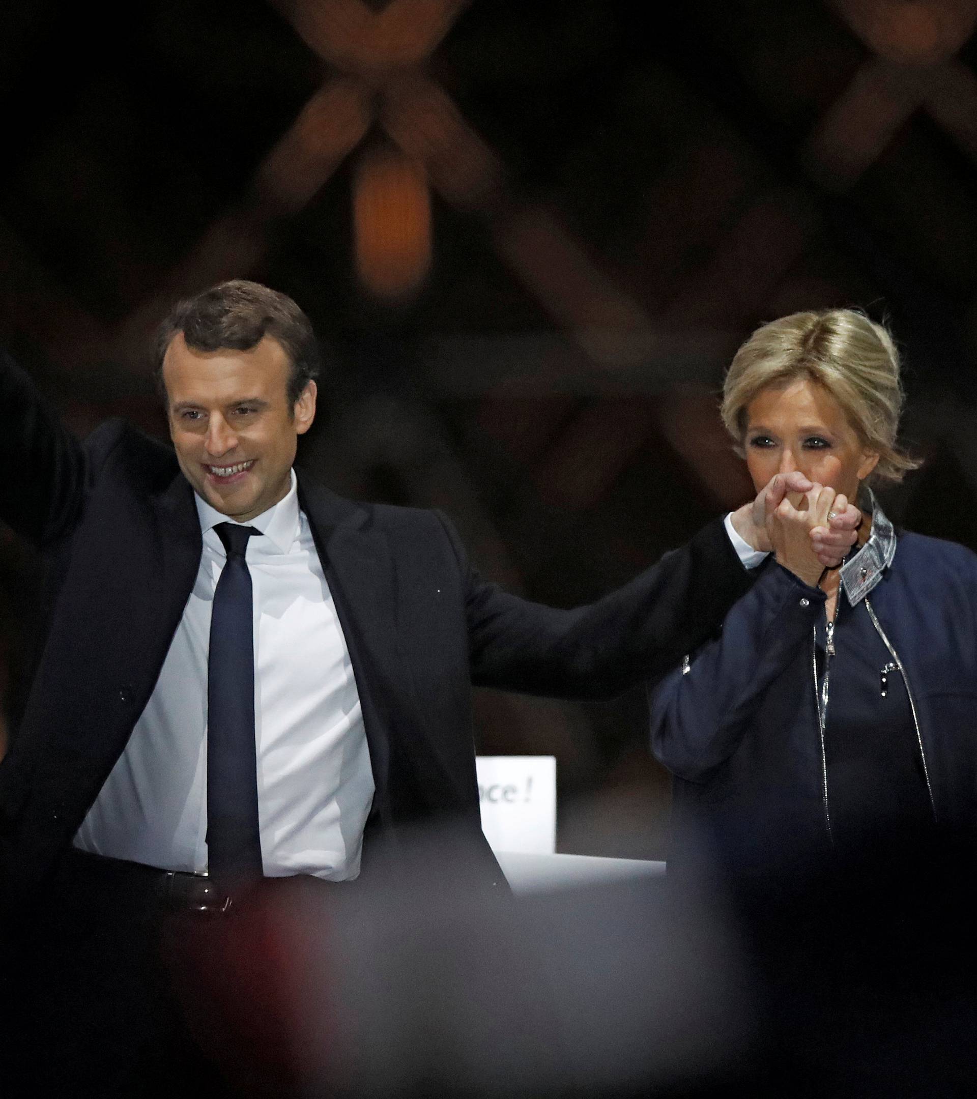 FILE PHOTO: French President elect Emmanuel Macron and his wife Brigitte Trogneux celebrate on the stage at his victory rally near the Louvre in Paris