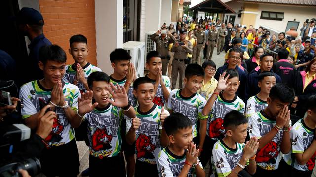 The 12 boys and their soccer coach who were rescued from a flooded cave arrive for a news conference in the northern province of Chiang Rai