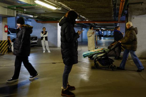 People take shelter inside an underground parking lot during a Russian missile and drone attack in Kyiv