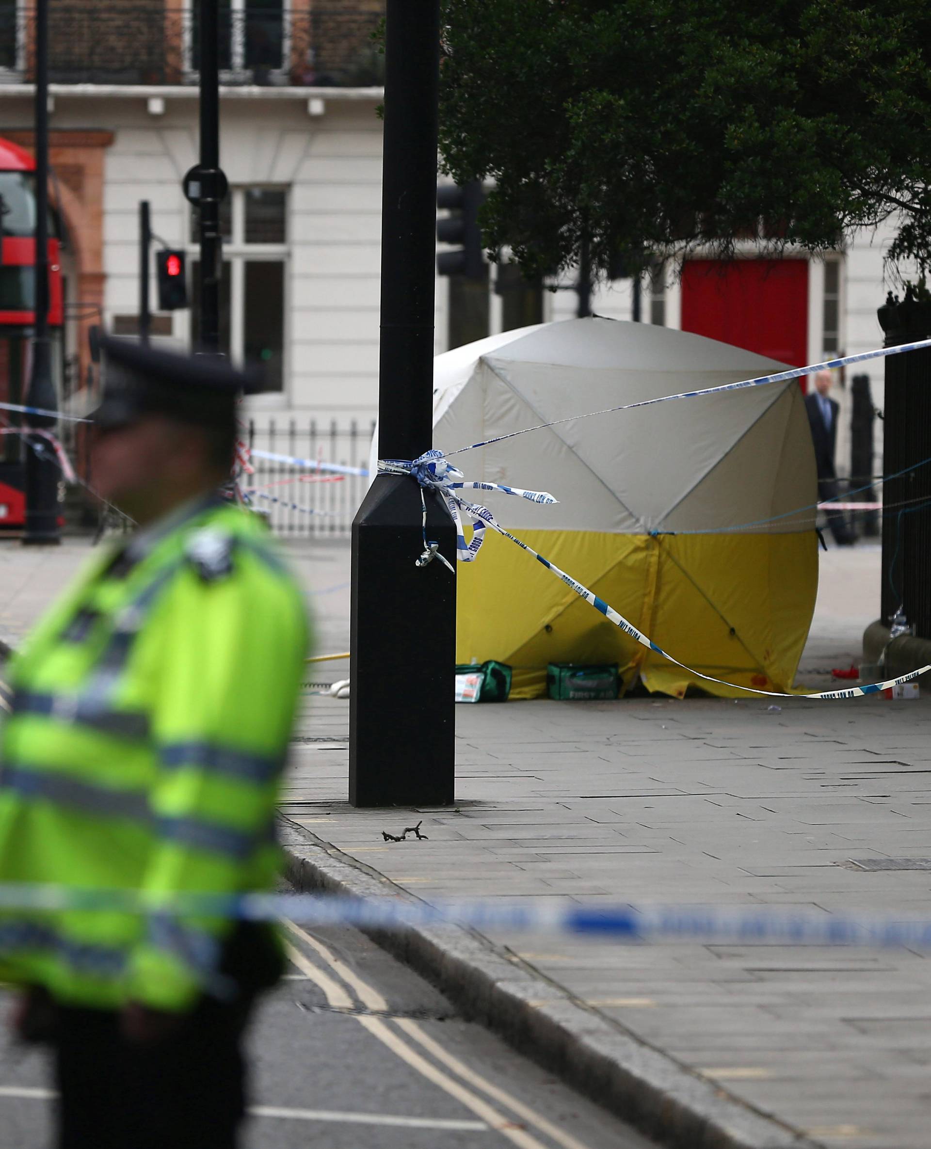 Police officers stand near a forensics tent after a knife attack in Russell Square in London