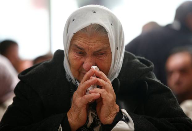 A woman reacts as she watches a television broadcast of the court proceedings of former Bosnian Serb general Ratko Mladic in the Memorial centre Potocari near Srebrenica