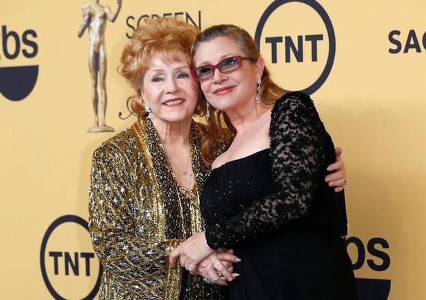 FILE PHOTO: Actress Debbie Reynolds poses with her daughter actress Carrie Fisher backstage after accepting her Lifetime Achievement award at the 21st annual Screen Actors Guild Awards in Los Angeles