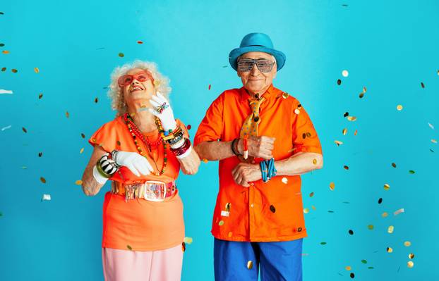Beautiful senior old couple wearing fancy party clothes acting in studio on a colored background. 