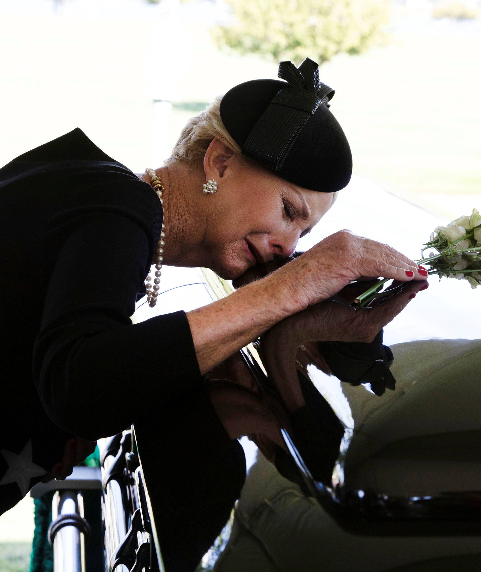 Cindy McCain lays her head on the casket of Sen. McCain during a burial service at the cemetery at the United States Naval Academy in Annapolis