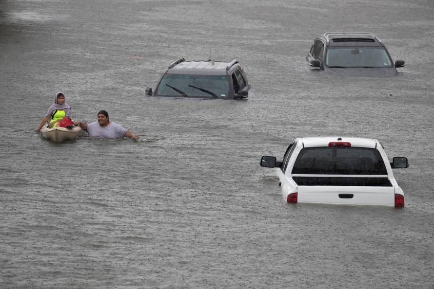 Jesus Rodriguez rescues Gloria Garcia after rain from Hurricane Harvey flooded Pearland, in the outskirts of Houston