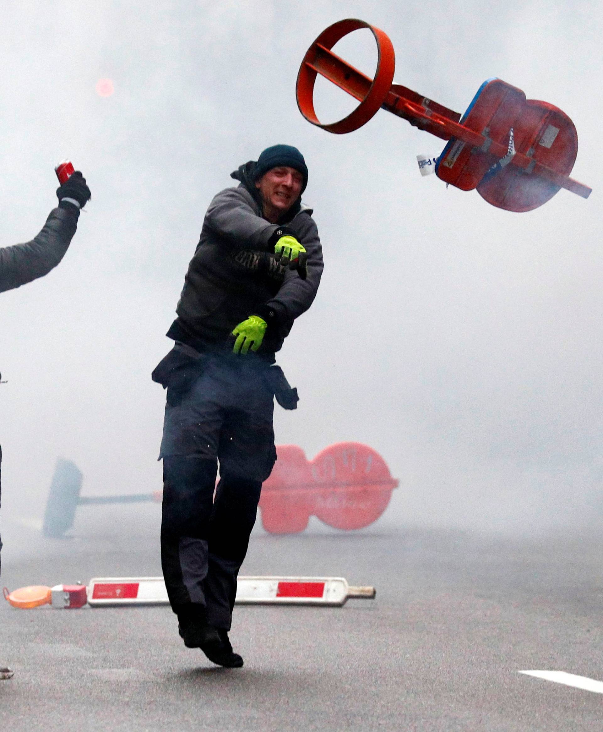 Far-right supporter throws a traffic sign during a protest against Marrakesh Migration Pact in Brussels