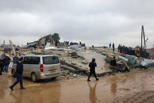Rescuers search for survivors under the rubble, following an earthquake, in rebel-held town of Jandaris