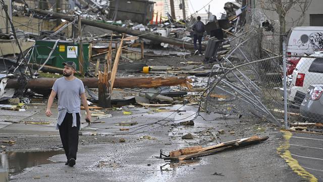 A man views damage in an alley behind Woodland Street after a tornado touched down in Nashville