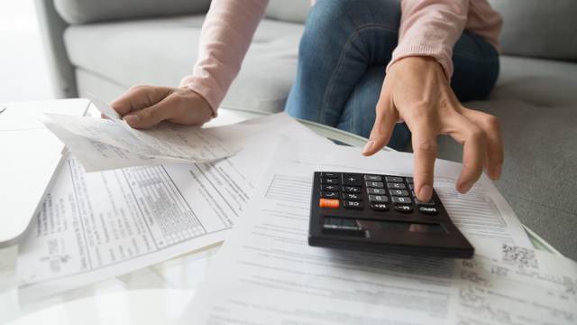 Woman,Renter,Holding,Paper,Bills,Using,Calculator,For,Business,Financial