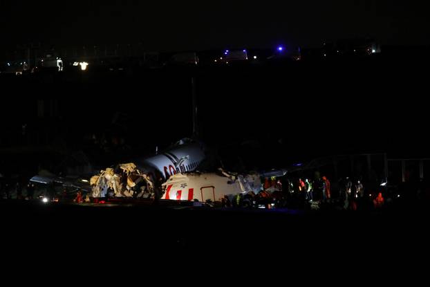 Firefighters and rescue teams are seen next to the wreckage of a plane after it crashed at Sabiha Gokcen airport in Istanbul