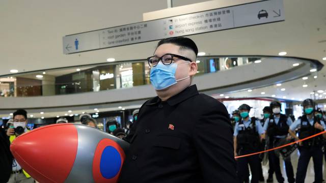 Howard X, an Australian-Chinese impersonating North Korean leader Kim Jong-un walks near riot police as officers clear the crowd in a mall to avoid the spread of the coronavirus disease (COVID-19) during an anti-government protest in Hong Kong