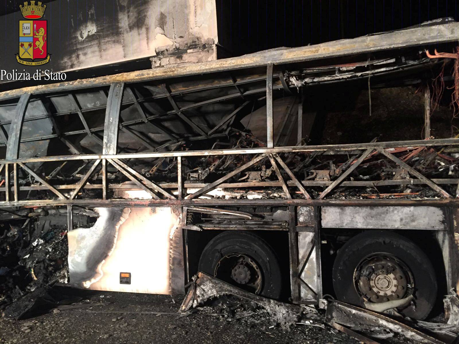 A charred bus, which was carrying Hungarian students, is seen on a side of a highway, near Verona