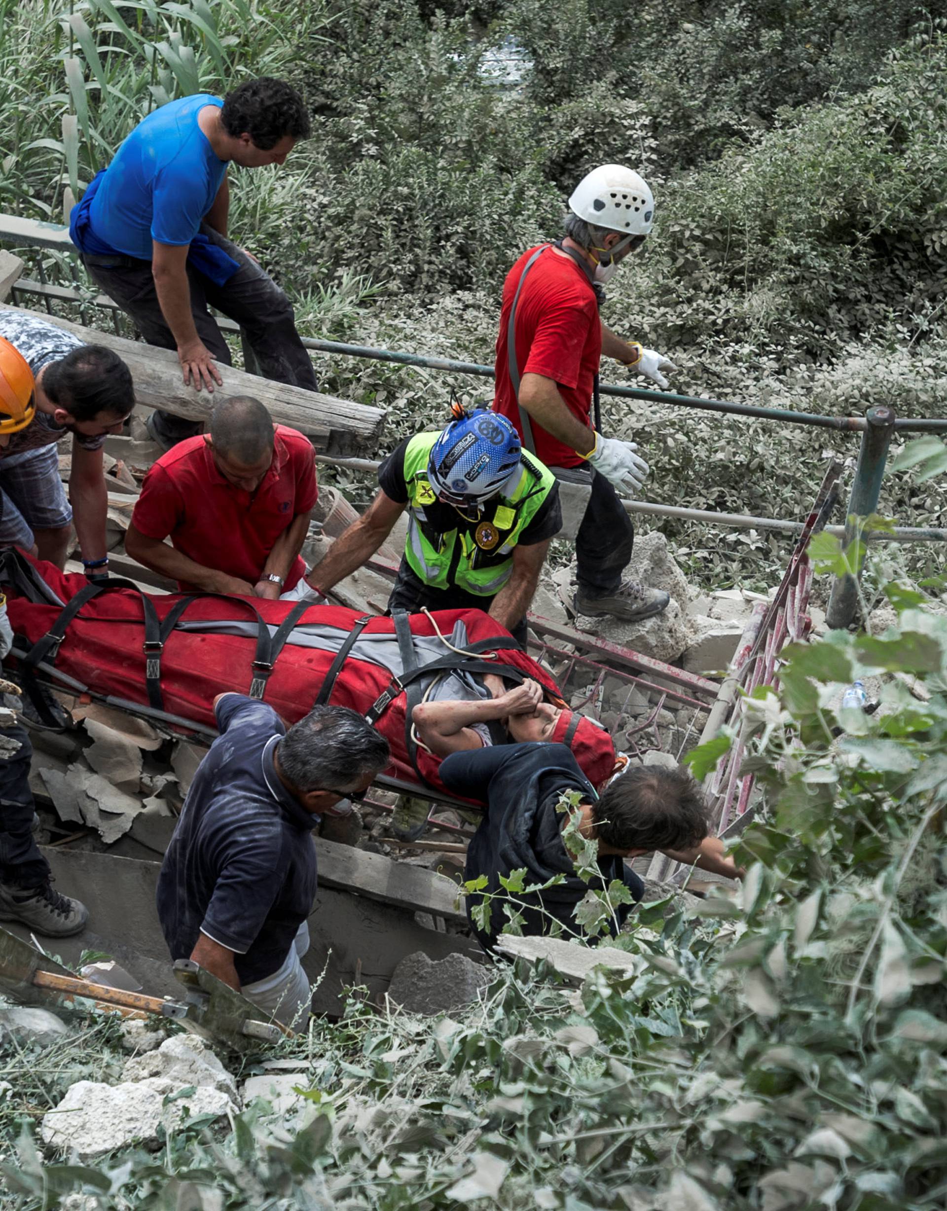 A wounded person is carried out from a collapsed building following an earthquake in Pescara del Tronto