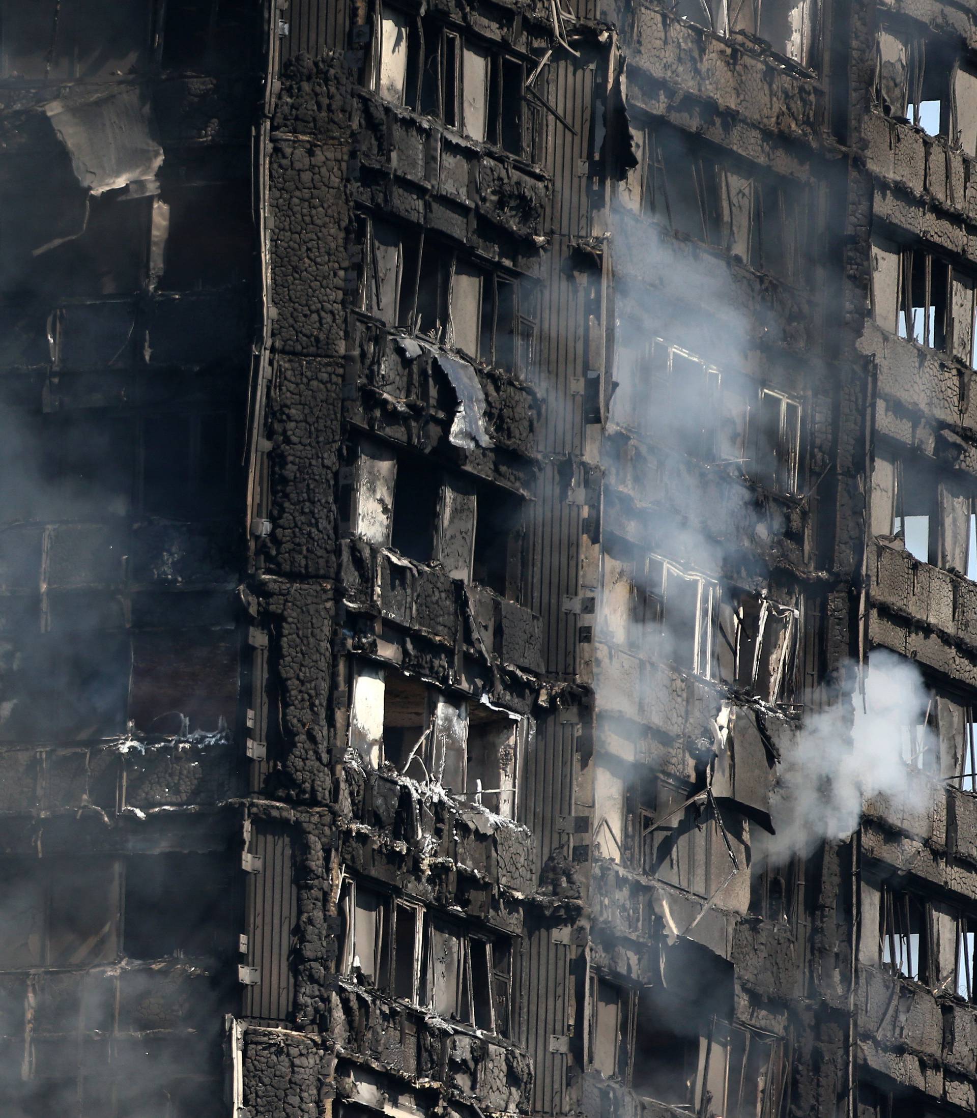 Flames leap from a tower block severly damaged by a serious fire, in north Kensington, West London