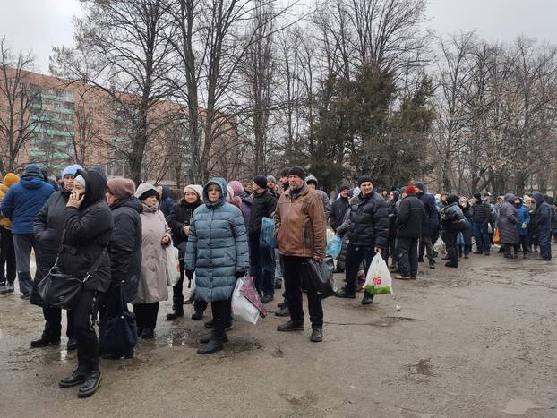 Local residents queue to receive food at the territory of a local in Kharkiv