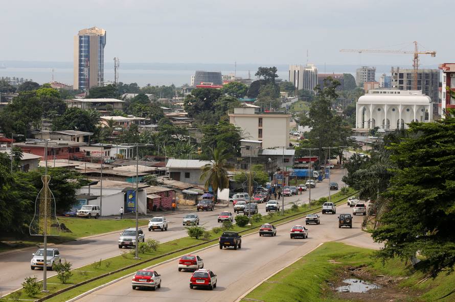 FILE PHOTO: Cars drive down a highway beneath the skyline of Libreville, Gabon's capital