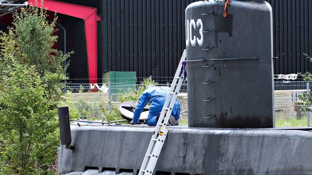Police technicians investigate the rescued private submarine "UC3 Nautilus" in Copenhagen Harbor