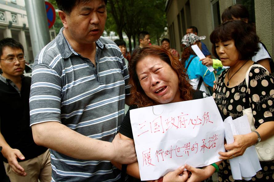 A family member of a passenger aboard Malaysia Airlines flight MH370 which went missing in 2014 reacts during a protest outside the Chinese foreign ministry in Beijing