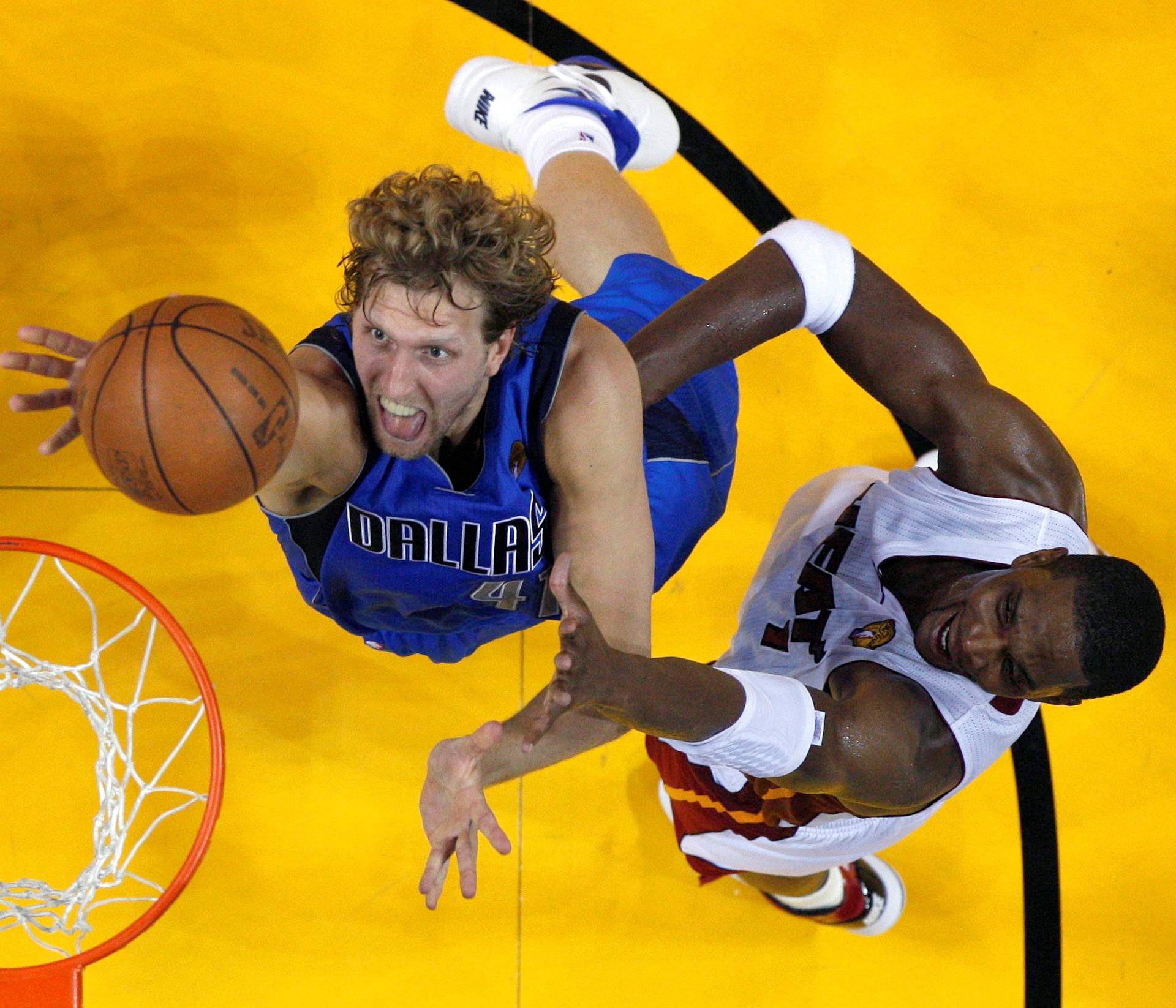 File Photo Dallas Mavericks' Nowitzki of Germany shoots past Miami Heat's Bosh during the first half in Game 1 of the NBA Finals in Miami