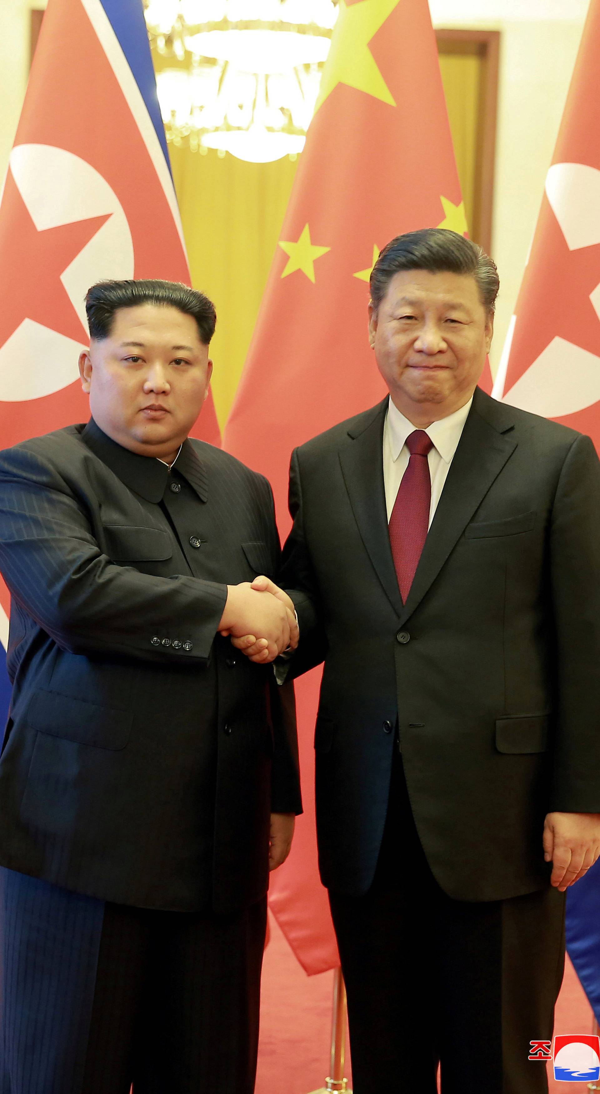 North Korean leader Kim Jong Un shakes hands with Chinese President Xi Jinping as he paid an unofficial visit to China