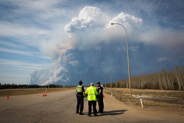 Officers look on as smoke from Fort McMurray