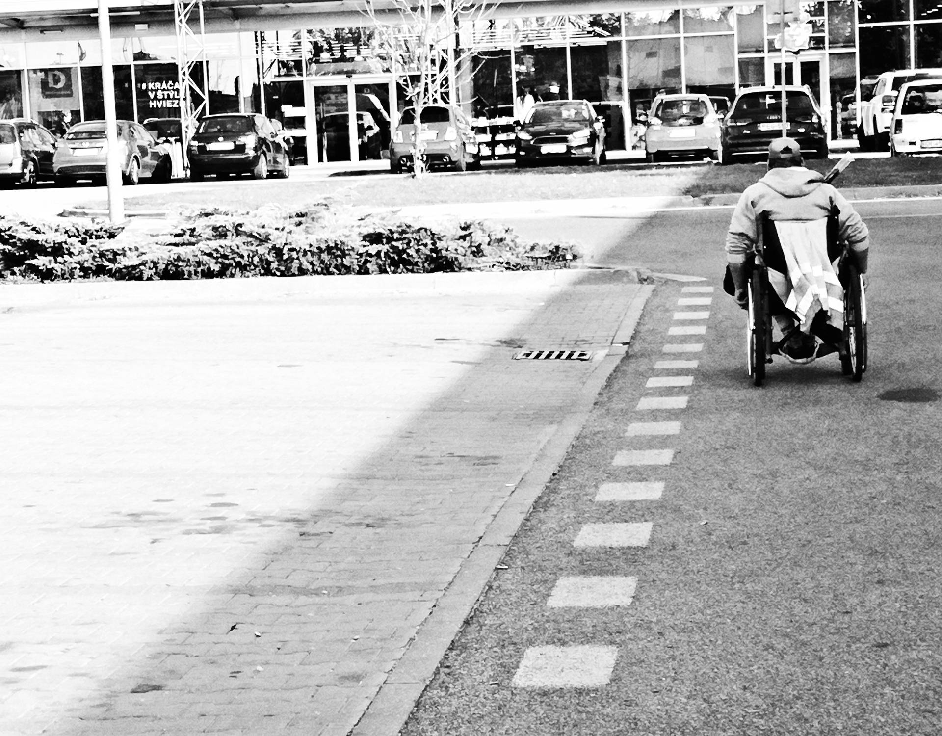 A man using wheel chair on an empty road in Stuttgart - Germany. Black and white image