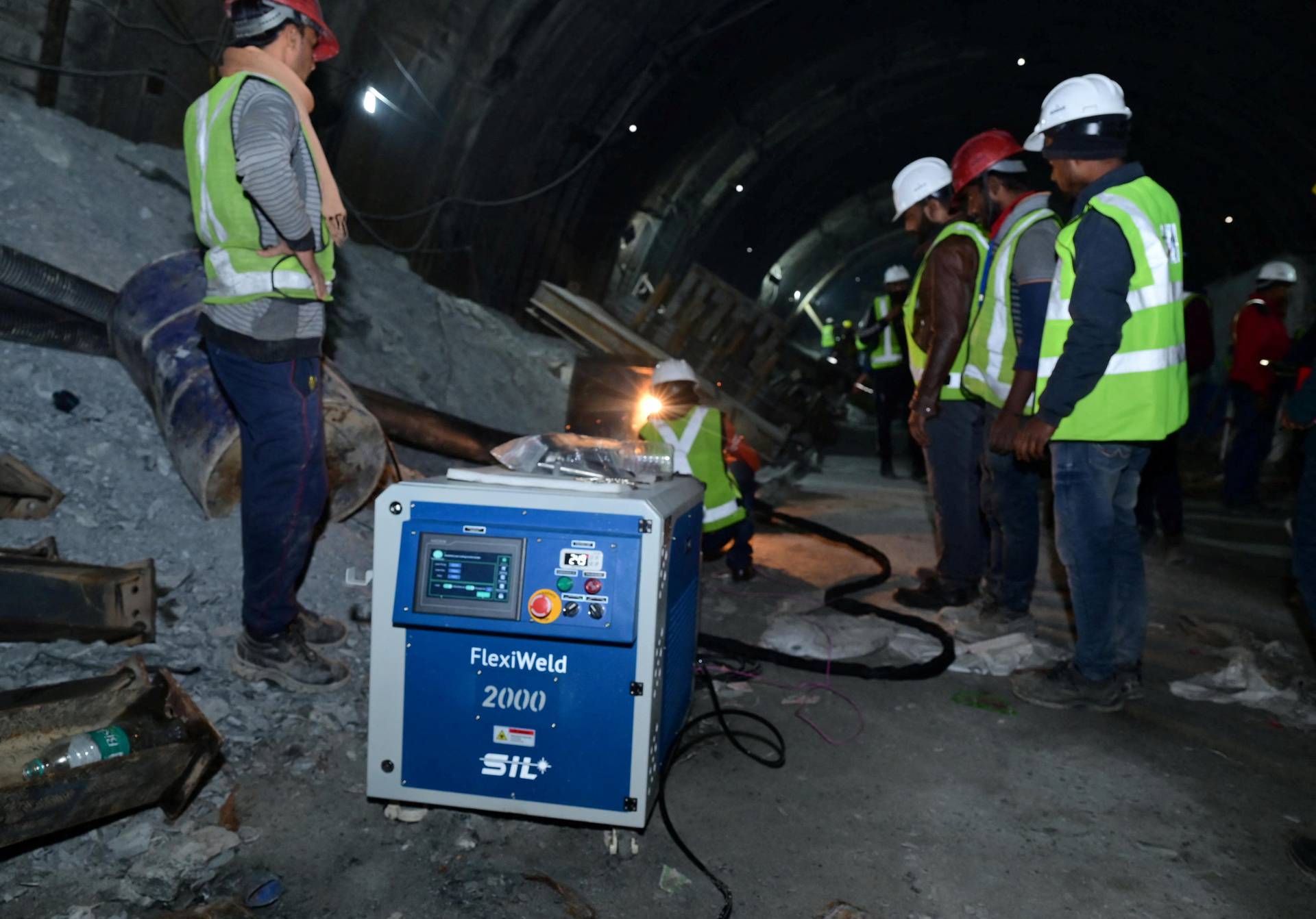 Rescuers fix parts of an auger machine inside a tunnel where workers are trapped after a portion of the tunnel collapsed in Uttarkashi