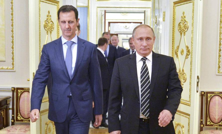 Russian President Vladimir Putin and Syrian President Bashar al-Assad enter a hall during a meeting at the Kremlin
