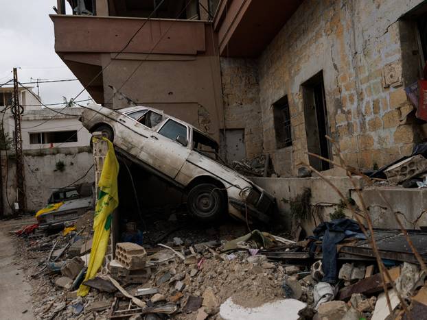 People cross a damaged bridge in Zrarieh