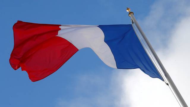 FILE PHOTO: A French flag flutters in the sky over the Elysee Palace in Paris