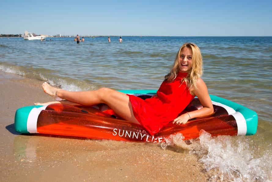 Marta Kostyuk of Ukraine sits on a float during an official event promoting the Australian Open tennis tournament at Albert Park beach in Melbourne