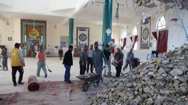 People remove rubble from a damaged mosque following an earthquake in Khanaqin