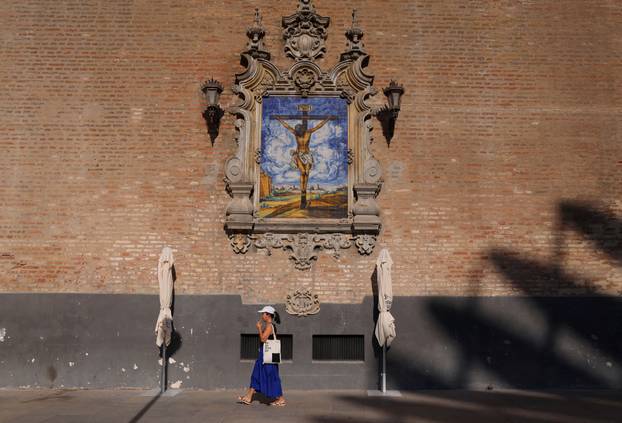A tourist walks during a heatwave in Seville