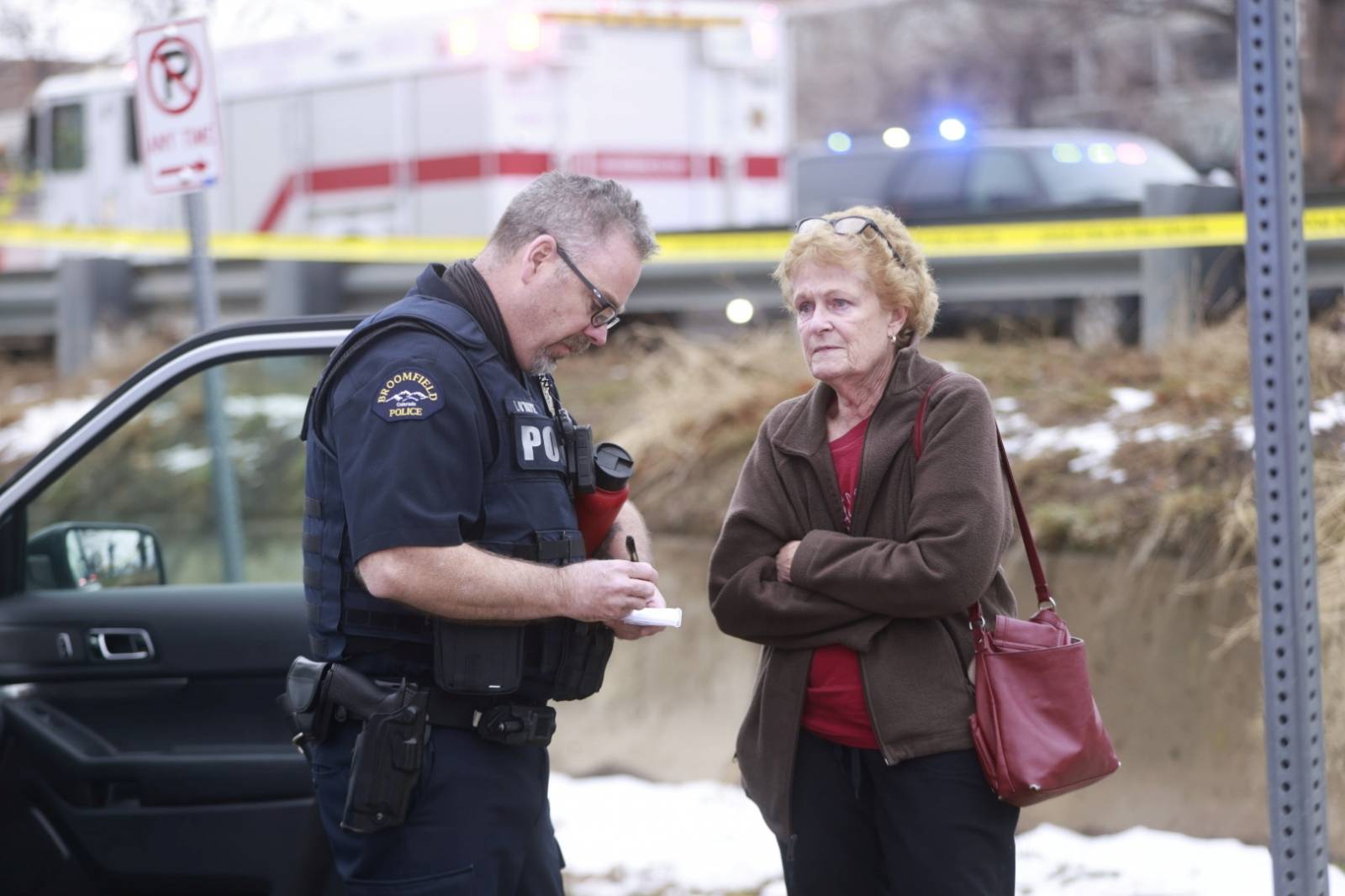 A law enforcement officer speaks with a women outside the perimeter of a shooting site at King Soopers grocery store in Boulder