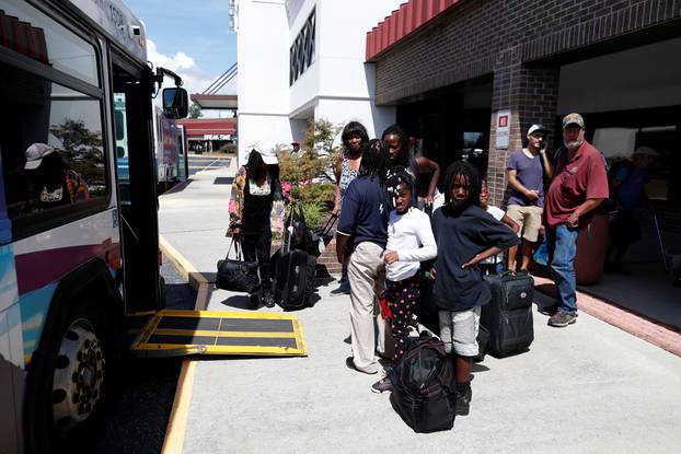 People wait in line for an evacuation bus to Raleigh, North Carolina ahead of the arrival of Hurricane Florence in Wilmington