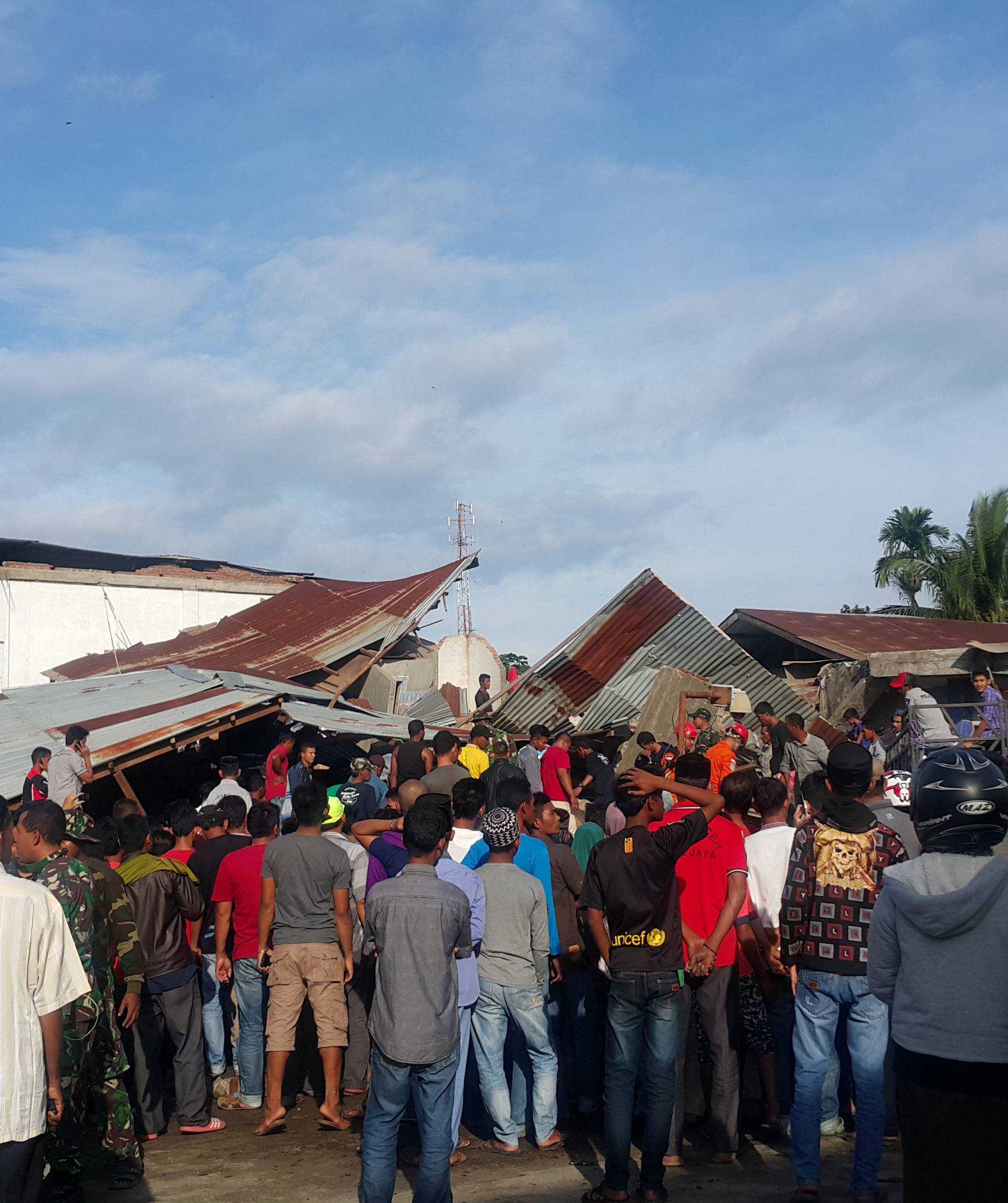 People survey the damage after dozens of buildings collapsed following a 6.4 magnitude earthquake in Ule Glee, Pidie Jaya in the northern province of Aceh
