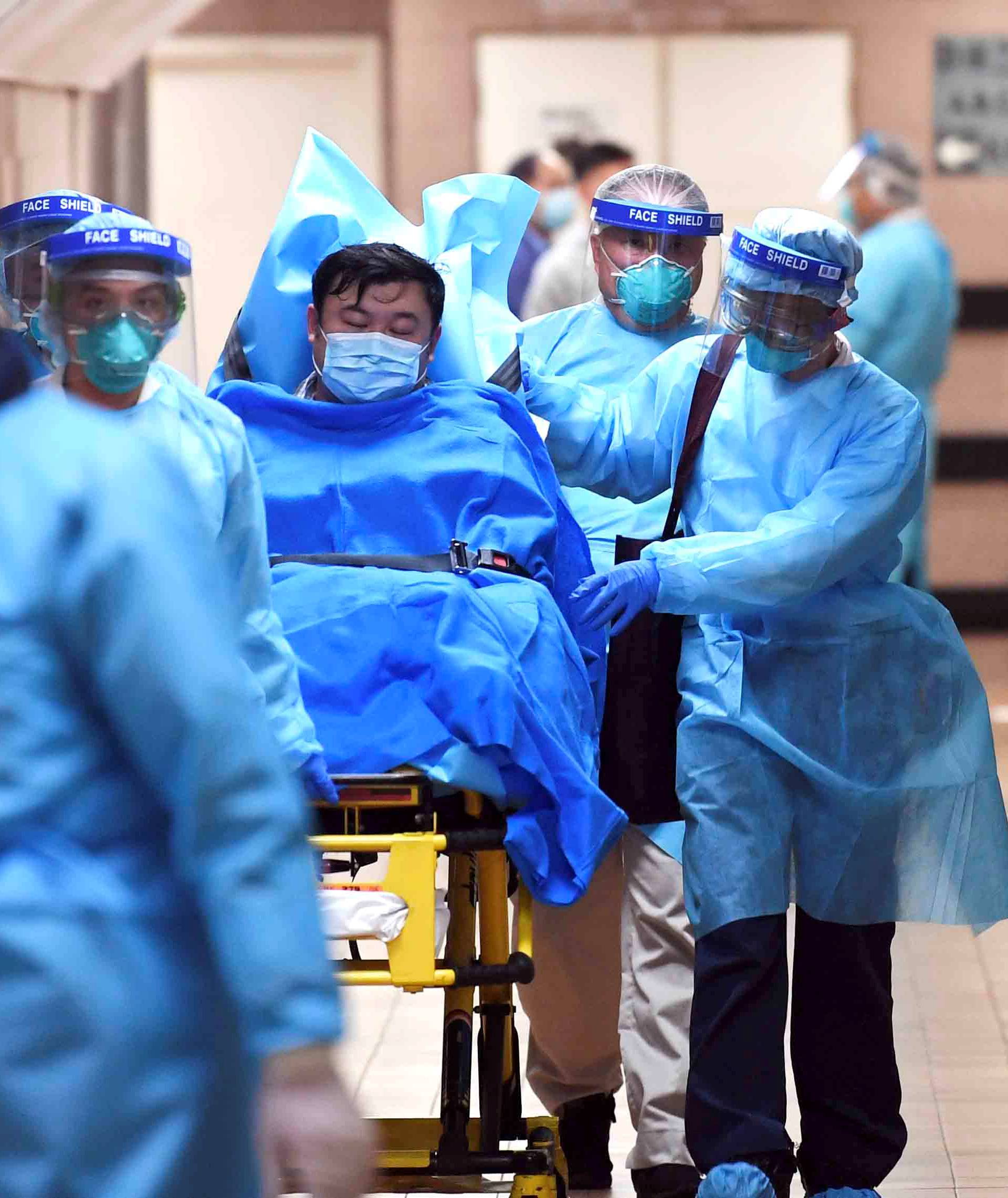 Medical staff transfer a patient of a highly suspected case of a new coronavirus at the Queen Elizabeth Hospital in Hong Kong