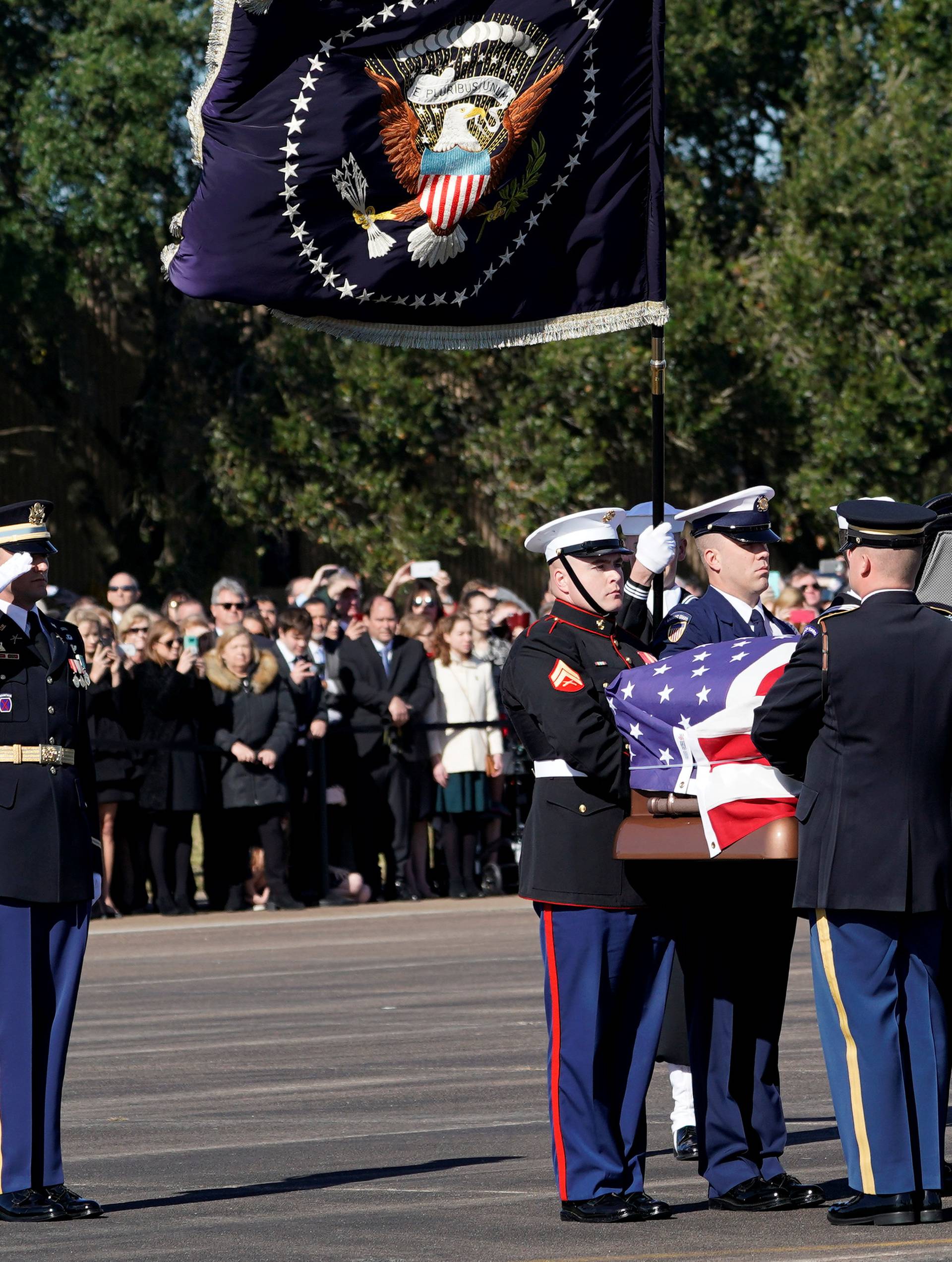 Flag-draped casket of former U.S. President Bush is carried by a joint services military honor guard in Houston