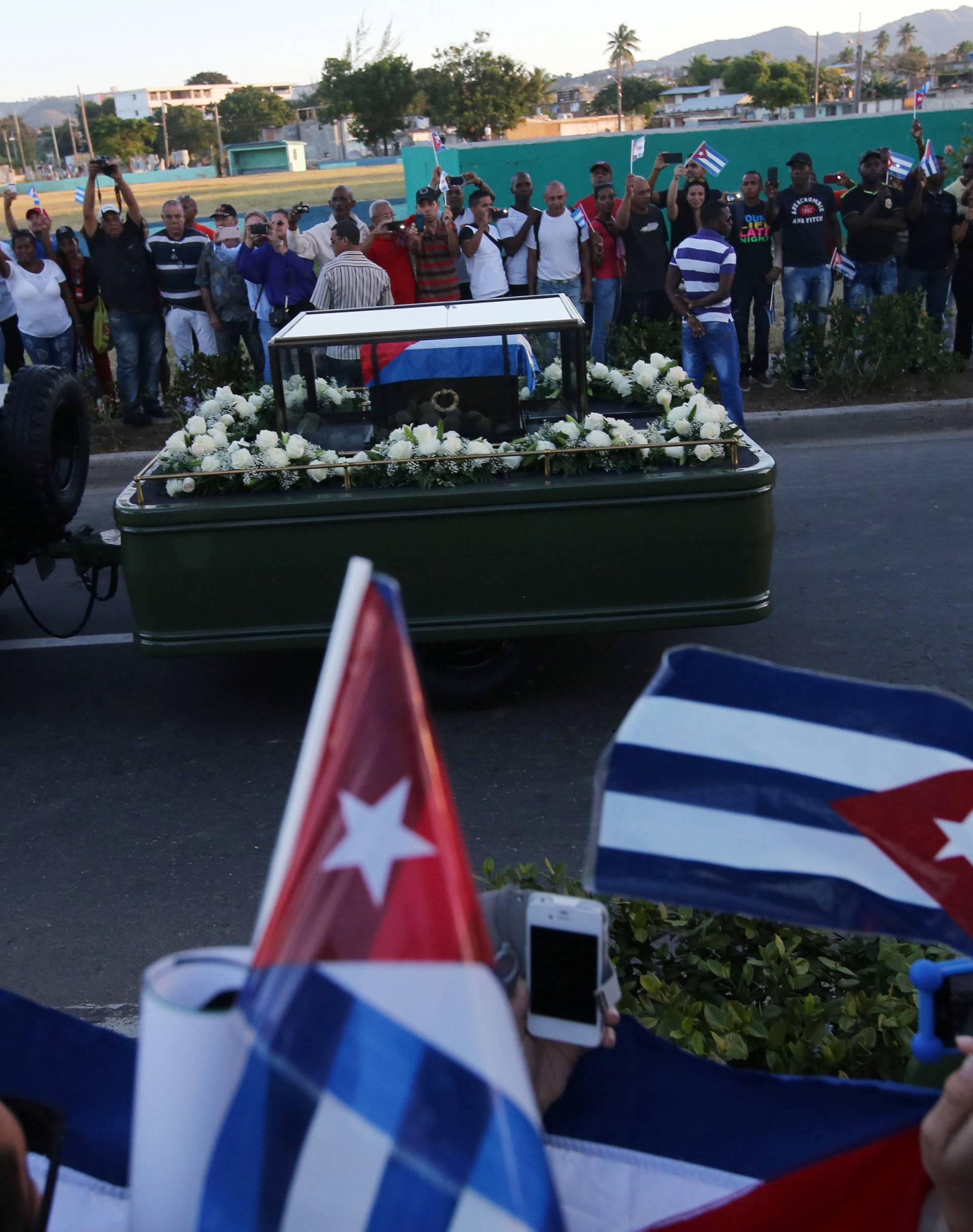 People watch the cortege carrying the ashes of Cuba's former President Fidel Castro drive toward Santa Ifigenia cemetery in Santiago de Cuba