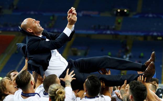 FILE PHOTO: Real Madrid players give coach Zinedine Zidane the bumps as they celebrate winning the Champions League at San Siro stadium in Milan
